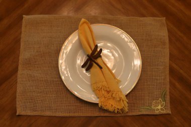 Masa Yeri Beyaz tabak ve sarı peçeteyle ayarlanıyor