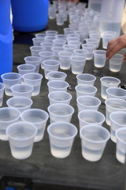 Tek kullanımlık plastik bardaklar masanın üstünde.