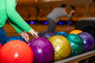 Bowling salonunda bovling topunu almak isteyen bir çocuğun elleri