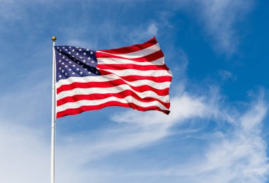 Rüzgarda dalgalanan güzel Amerikan bayrağı, mavi gökyüzüne karşı canlı kırmızı beyaz ve mavi renkler, kopyalama alanı ile.