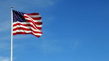 Rüzgarda dalgalanan Amerikan bayrağı, mavi gökyüzüne karşı canlı kırmızı beyaz ve mavi renklerle, kopyalama uzayı ile.
