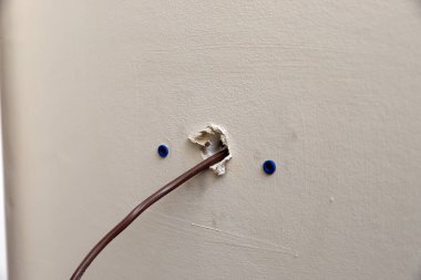 Kurulum sırasında duvardan çıkan bir HVAC ünitesi ile kullanılan termsotat için kontrol kablosu