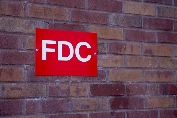 Fire Department Connection Sign on brick wall of building