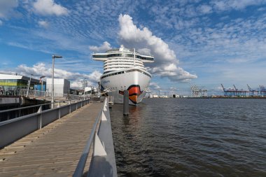 Hamburg Limanı 'ndaki AIDA Perla yolcu gemisi. Almanya' nın Rıhtım Bölgesi yakınlarındaki Altona Cruise Center 'da güzel bulutları olan harika bir gökyüzü.