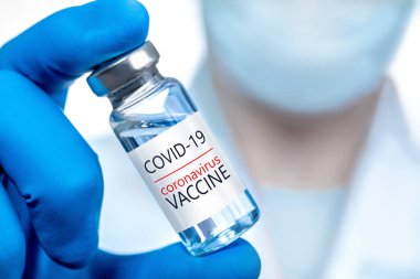 Coronavirus aşısı COVID-19 'un geliştirilmesi ve yaratılması. Coronavirus aşısı kavramı doktor mavi aşı kavanozunun elinde. Aşı Coronavirus 'a karşı savaş kavramı.