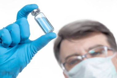 Coronavirus aşısı COVID-19 'un geliştirilmesi ve yaratılması. Coronavirus aşısı kavramı doktor mavi aşı kavanozunun elinde. Aşı Coronavirus 'a karşı savaş kavramı.