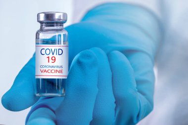 Coronavirus aşısı COVID-19 'un geliştirilmesi ve yaratılması. Coronavirus aşısı kavramı doktor mavi aşı kavanozunun elinde. Aşı Coronavirus 'a karşı savaş kavramı