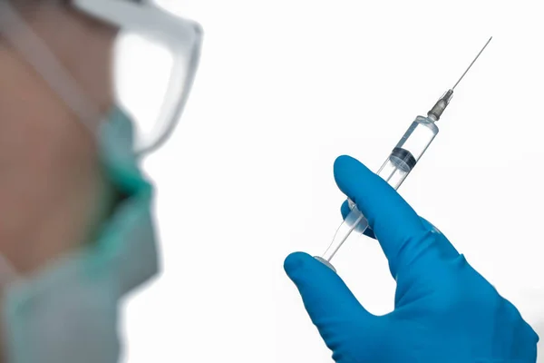 Elinde şırıngayla tıp eldivenli doktor. Coronavirus 'a karşı savaşma kavramı.