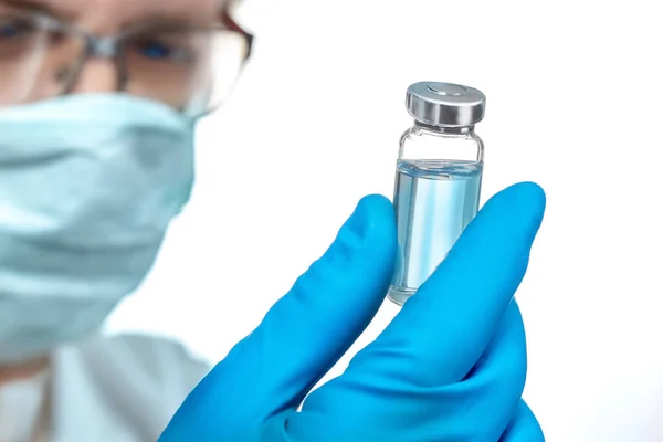 Coronavirus aşısı COVID-19 'un geliştirilmesi ve yaratılması. Coronavirus aşısı kavramı doktor mavi aşı kavanozunun elinde. Aşı Coronavirus 'a karşı savaş kavramı.