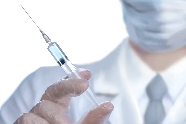 Elinde şırıngayla tıp eldivenli doktor. Coronavirus 'a karşı savaşma kavramı.