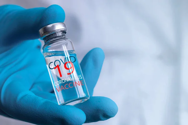 Coronavirus aşısı COVID-19 'un geliştirilmesi ve yaratılması. Coronavirus aşısı kavramı doktor mavi aşı kavanozunun elinde. Aşı Coronavirus 'a karşı savaş kavramı.