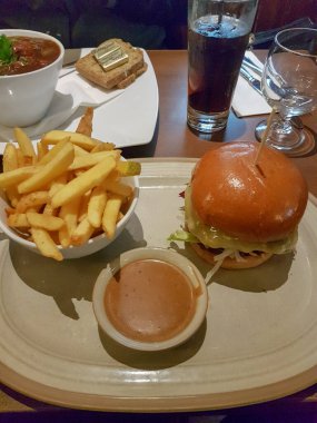 Patates kızartmalı hamburger ve soslu pancar çorbası kafede masanın üstünde, yakın görüş.