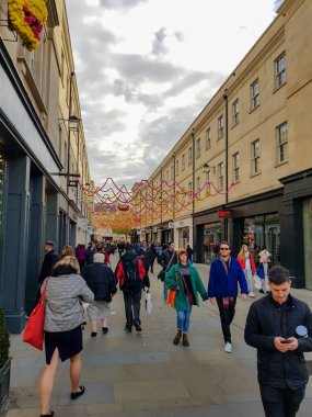 Turistler şehirde binaların arasında sokakta yürüyorlar