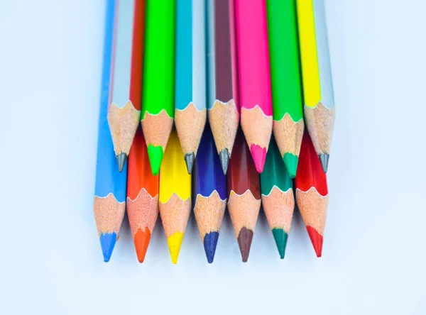 白い背景に別の上に置かれた様々な色の木の鉛筆のクレヨンの列の束 — ストック写真