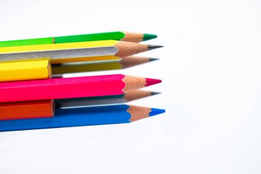 Çember şeklinde bir araya getirilmiş bir sürü farklı renkli tahta kalem kalemi var.