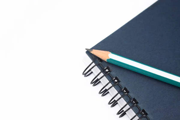 深い青の色のノート紙の日記に置かれた薄い青の色の木製の鉛筆クレヨン — ストック写真