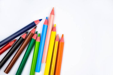 Beyaz bir kağıda serpiştirilmiş farklı renkte tahta kalemlerin fotoğrafı.