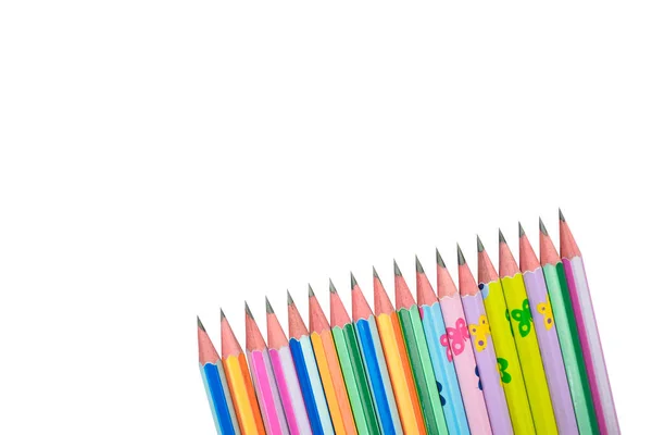 许多不同颜色的铅笔蜡笔放在白纸的背景上 — 图库照片