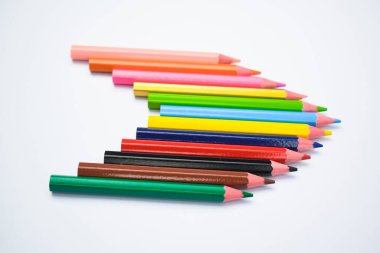 Beyaz kağıt arka planda farklı tahta kalemlerle yapılmış harika bir ok deseni.