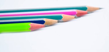 Beyaz kağıt arka planda beş farklı renkte tahta kalem boyası yan yana yerleştirilmiş.