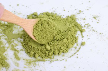 Beyaz arkaplanda yeşil toz izole edildi