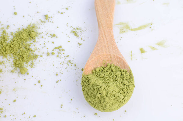 зеленый порошок на ложке изолированы на белом фоне
