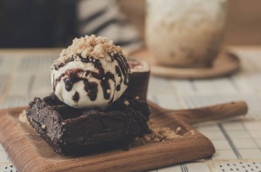 Ahşap tabakta dondurma ve kremalı hommade brownie. 