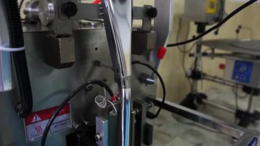 Büyük bir girişimde yiyecek paketlemek için otomatik paketleme için kullanılan teknik cihazın çalışma süreci. Yakın plan.