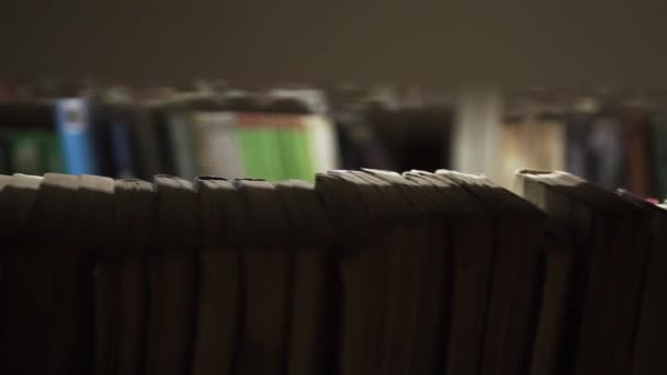 Молодой Кавказский Мужчина Розовой Рубашке Входит Темную Комнату Библиотеки Между — стоковое видео