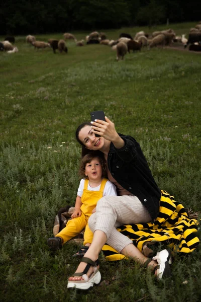 Anne ve çocuk sahada selfie çekiyorlar. Taşradaki hayatın sunumu için. Güzel köy. Tarlada yürü..