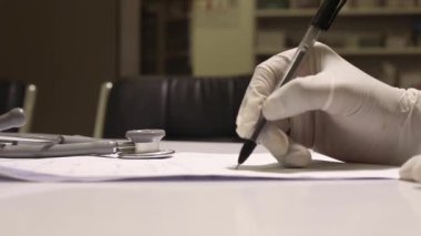 Doktor reçetesini beyaz kağıda yazıyor, doktor odası, tıbbi konsept, doktor muayenesi.