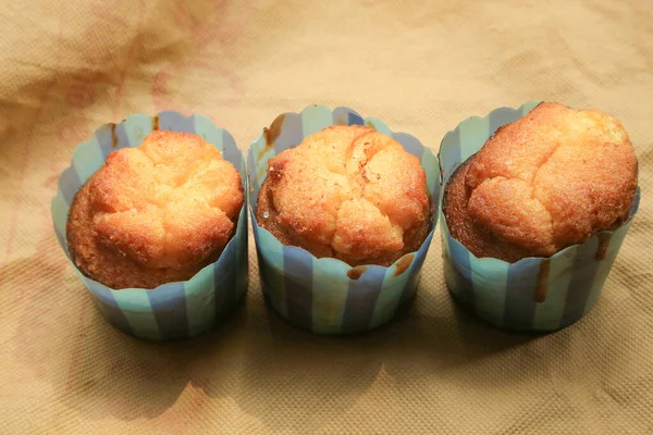 Frische Hausgemachte Leckere Muffins Vor Cremigem Hintergrund — Stockfoto