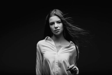 Güzellik. Kadınlık. Mükemmel bir cilde sahip güzel bir kadın yüzü. Güzellik salonu. Makyöz. Stüdyoda güzel bir kadının portresi. Kız saçını şişiriyor. Beyaz gömlekli kız. Yüz.