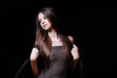 Siyah elbiseli genç bir kadın saçlarına dokunuyor. - Tamam. Saçlar. Elbiseli kız. Moda. Doğal kozmetik ürünleri ve güzel parlak makyajlar. Güzel genç kız. Bir kızın portresi..