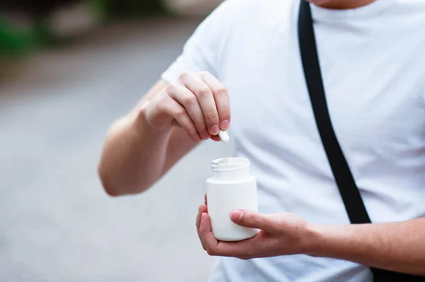 白い背景に隔離された手に白いプラスチックボトルで錠剤を注ぐ大人の女性の手 大人の健康管理 催眠術と不眠症の概念 — ストック写真