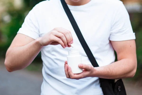白い背景に隔離された手に白いプラスチックボトルで錠剤を注ぐ大人の女性の手 大人の健康管理 催眠術と不眠症の概念 — ストック写真