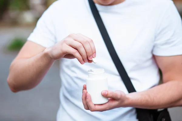 白い背景に隔離された手に白いプラスチックボトルで錠剤を注ぐ大人の女性の手 大人の健康管理 催眠術と不眠症の概念 — ストック写真