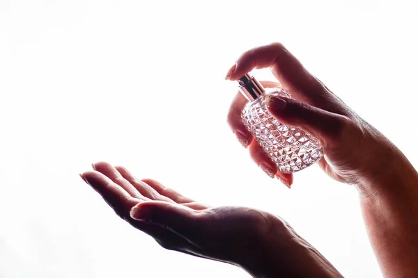 Woman applying perfume on her hand. Woman applying perfume on her wrist perfume bottle.