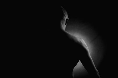 Kas büyüsü ve insanın arkası. Kas gösterisi. Alçakgönüllülük. Siyah beyaz fotoğraf. Kaslı, seksi vücutlu ve sırtı açık bir erkek model..