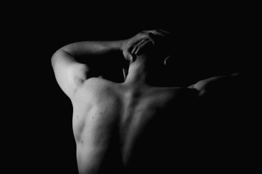 Baş ağrısı. Kas büyüsü ve insanın arkası. Kas gösterisi. Siyah beyaz fotoğraf.