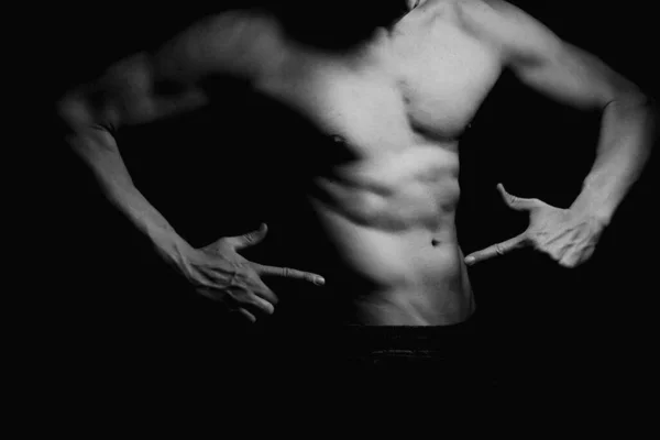 強い運動能力だボディビルダー 顔の肖像画は認められない 裸の胴 筋肉体 強い胸と肩の筋肉 黒を背景に撮影されたスタジオ 低キー ボディビルのコンセプト — ストック写真