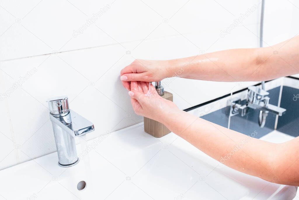 Hand washing with human soap and water to prevent coronavirus viruses, hygiene to stop the spread of coronavirus. Woman uses soap and washes her hands under the tap. Hand hygiene concept detail.