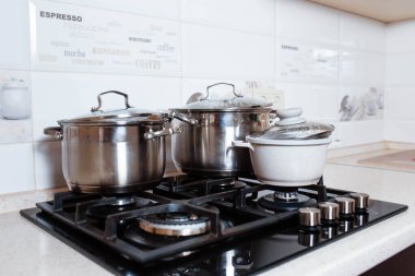 Mutfaktaki fırında pişirme dersleri için aletler. Mutfak tezgahında metal tavalar. Lokanta mutfağında aşçı kadın..