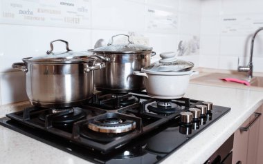 Mutfaktaki fırında pişirme dersleri için aletler. Mutfak tezgahında metal tavalar. Lokanta mutfağında aşçı kadın..