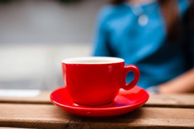Beyaz fincanda latte sanatıyla sıcak kahve ve ahşap bir masada çay tabağı. Köpüklü kapuçino. Tahta bir masada bir fincan kahve. Üst Manzara. Mesaj için yer. Sütlü kapuçino..
