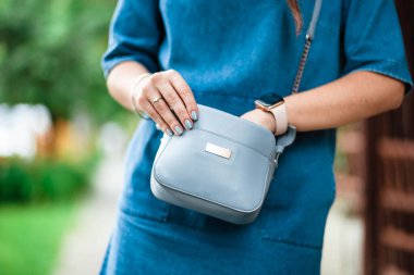 Bir kadının eli, akıllı telefonunu çantasında tutuyor. Seçici odaklanma. El çantası. Çanta kadınların elinde..