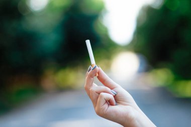 Elinde sigara olan bir kadın. Yaklaştın. Mesaj için yer. Sigara içmeyi bırakma kavramı. Sigara tutan bir kadın..