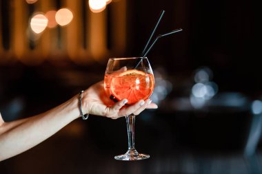 Bir kızın ellerinde Aperol spreyi. Aperol spreyi. Kokteyl.