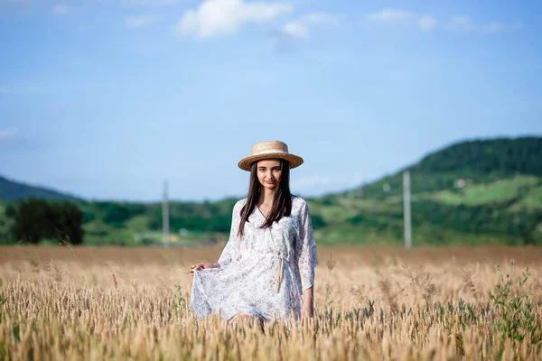 一个女孩在麦田里的画像 一个穿着白衣 头戴帽子的漂亮姑娘在麦田里的画像 穿白衣戴白帽的女孩 麦田一个年轻女子在大自然中的画像 — 图库照片