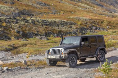 Kola Yarımadası. Murmansk bölgesi, Rusya Federasyonu, 10 Eylül 2018: Siyah Jeep Wrangler Sahara bir dağda geçmek Murmansk bölgede. Yol ve spor yeni araç